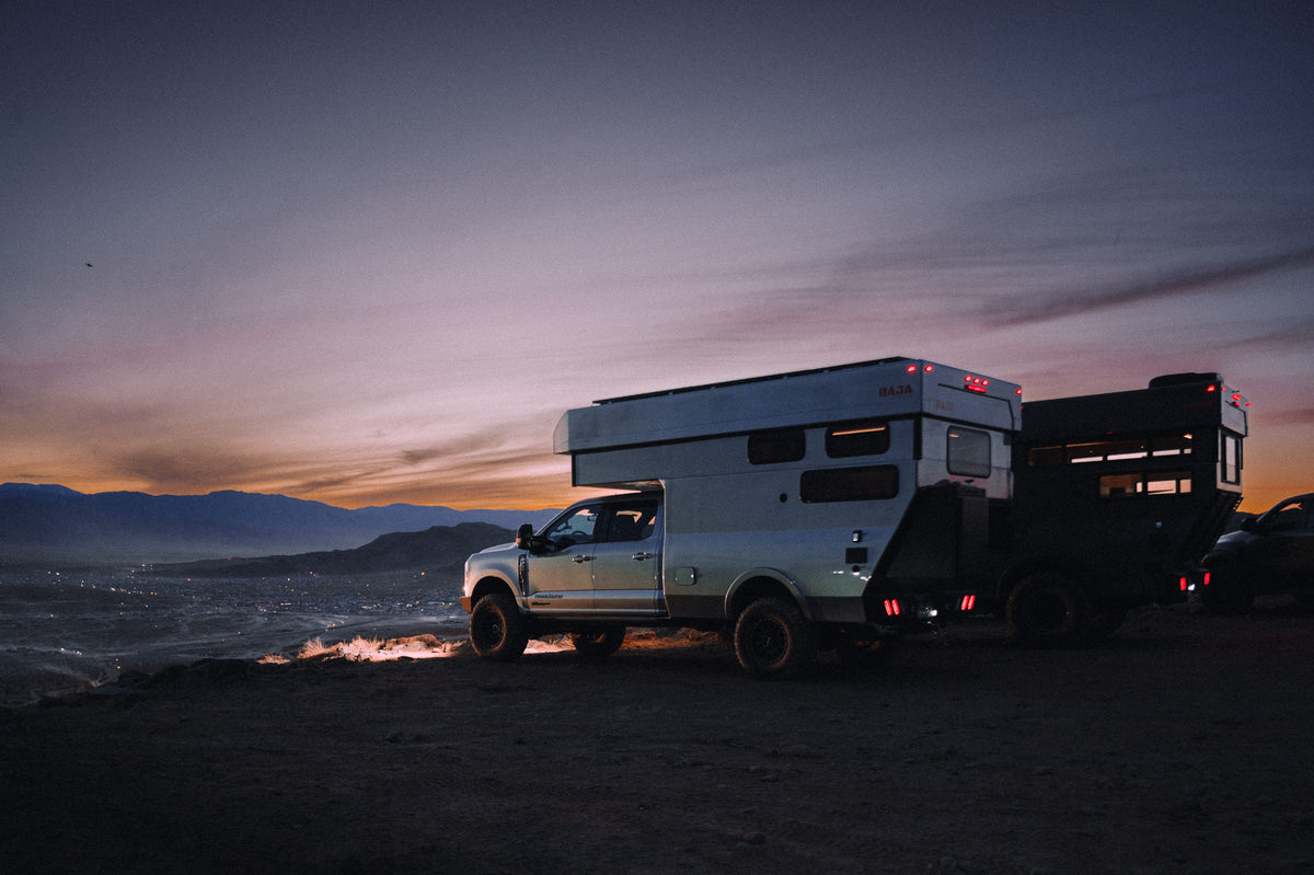 A Rossmönster rig parked at a campfire at dusk