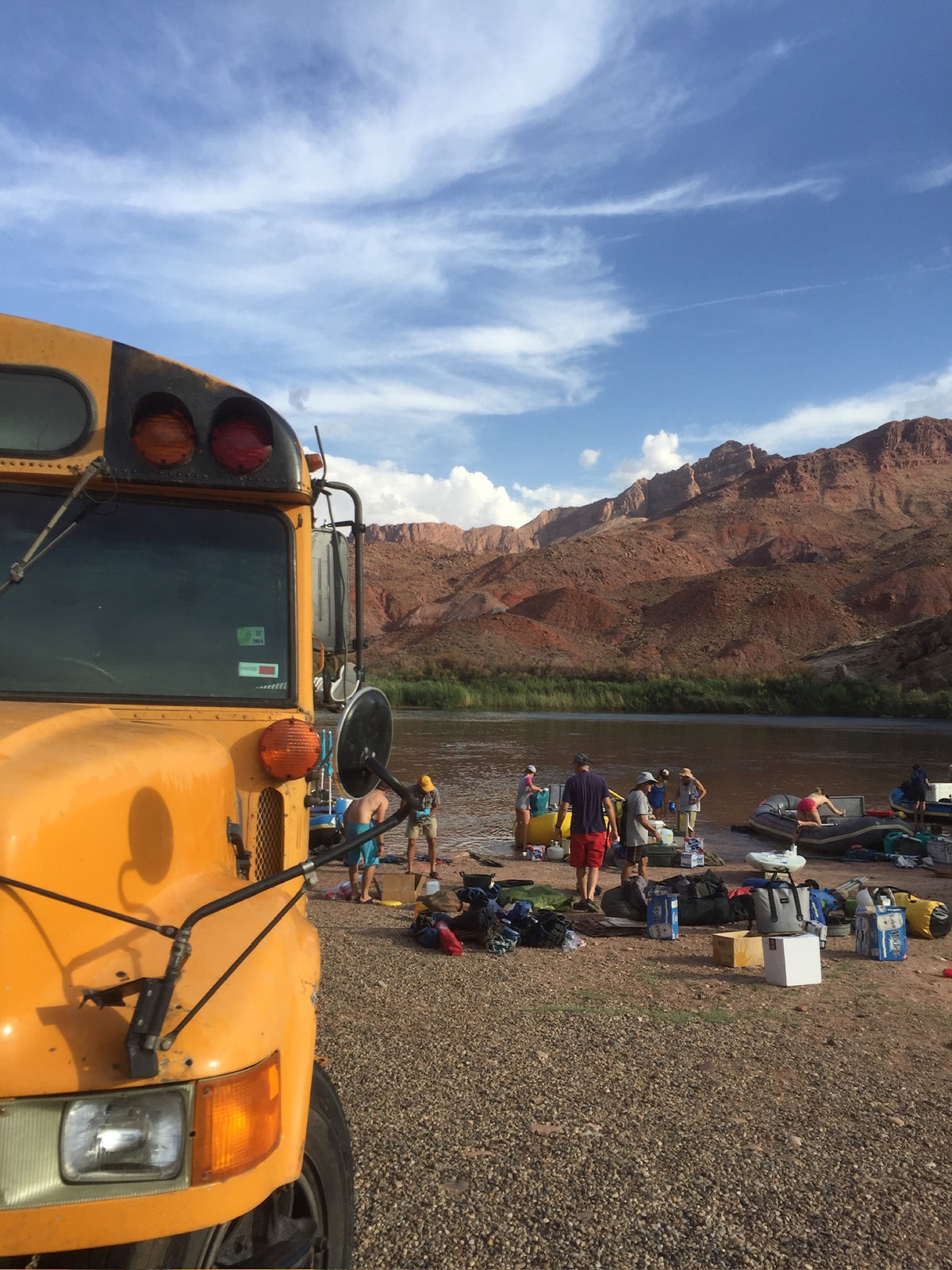 The bus at the put-in, rafts rigged on the Colorado