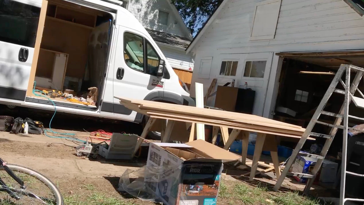 A ProMaster being built in the driveway, lumber on sawhorses