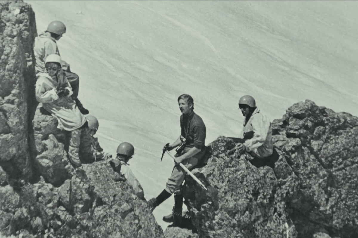 Roped up on a rocky ridge, ice axe in hand
