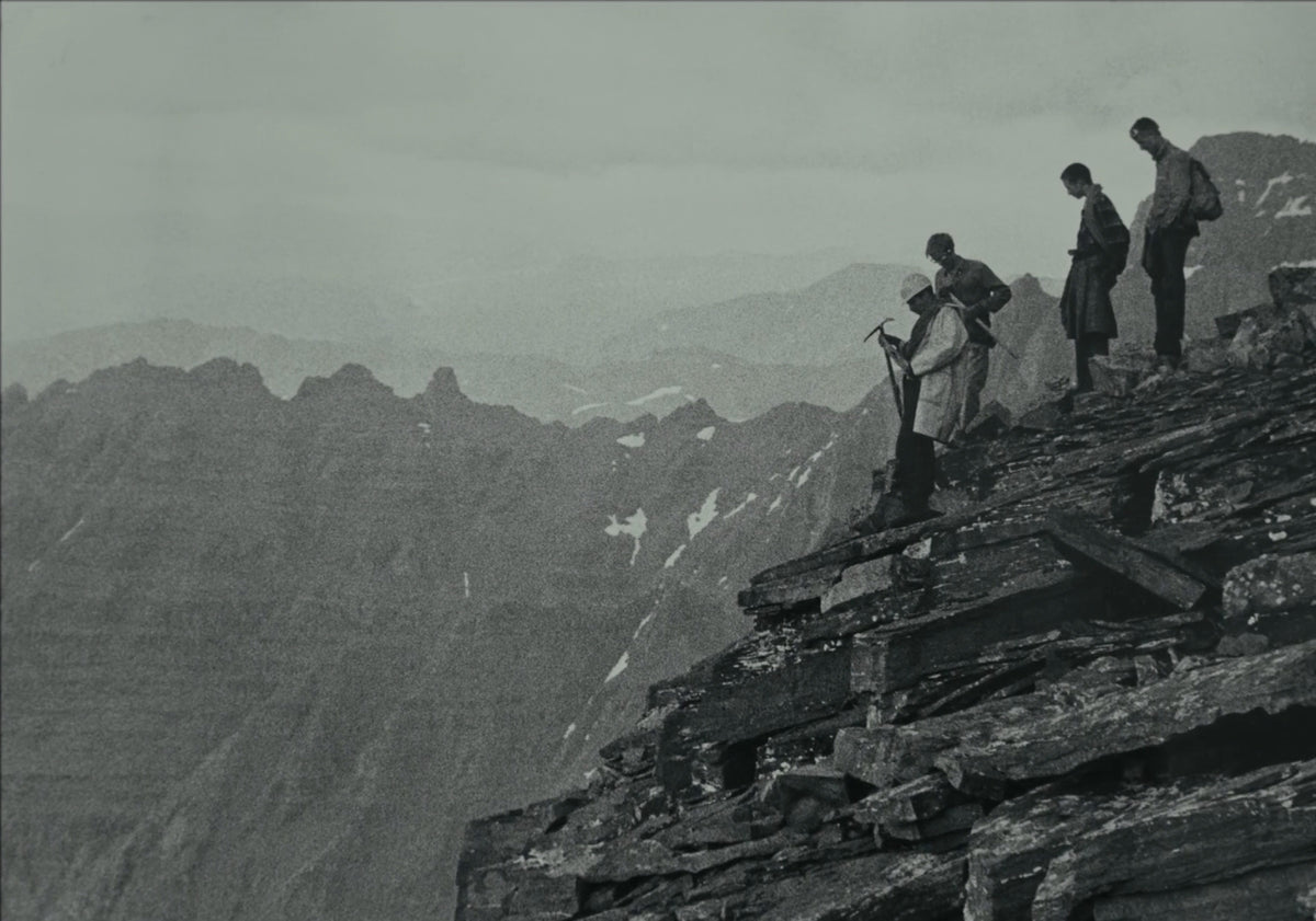 Four on a summit ridge, range on range behind
